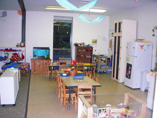 View of bead center, art center, dramatic play area and aquarium in preschool classroom.