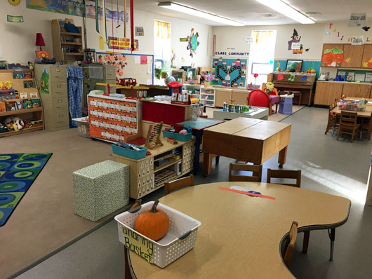 View of a a preschool classroom circle area and center areas with no children